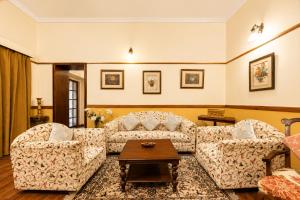 a living room with two couches and a coffee table at Springfields - A Heritage Palace Since 1902 by Eastlynn Experiences in Shimla