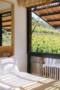 a bedroom with a bed and a large window at Casa do Lagar by Quinta de Recião in Lamego +36 photos