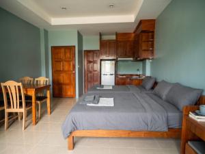 a bedroom with a large bed and a kitchen at Orient Hotel in Jomtien Beach