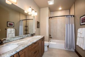 a bathroom with a sink and a tub and a toilet at Baker Loft 203 in Whitefish +6 photos