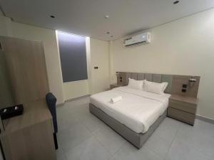 a bedroom with a white bed and a window at وتد الشرق للشقق المخدومة in Khafji