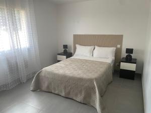 a bedroom with a large bed and a window at Apartment 65 m2 SE Rez de Jardin 2 chambres in Varetz