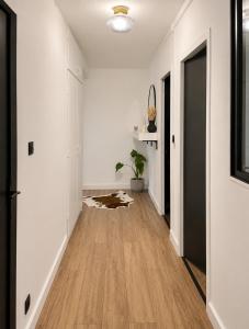 an empty hallway with white walls and a wooden floor at Cocon hyper centre de Pau avec parking in Pau