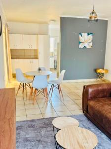 a living room with a couch and a table and chairs at Arise self catering in Burgersfort