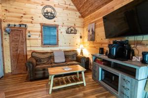 a living room with a couch and a tv at The Windstorm Cabin - Pet-friendly & a 2-person Jacuzzi hot tub! in Marshall