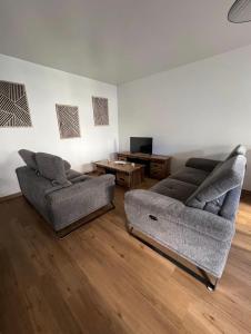 a living room with two couches and a table at La Maison Cocoon in Étampes