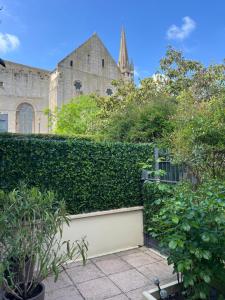 a hedge in front of a building with a church at La Maison Cocoon in Étampes