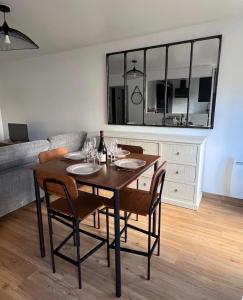a dining room with a table with chairs and a couch at La Maison Cocoon in Étampes