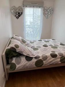 a bedroom with a bed with a comforter and a window at La Maison Cocoon in Étampes