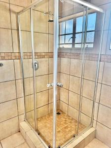 a shower with a glass door in a bathroom at Arise self catering in Burgersfort