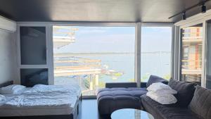 a living room with a couch and a large window at OW Mewa domki apartamenty nad jeziorem in Nysa