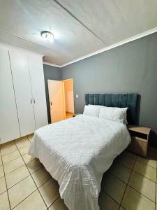 a bedroom with a large bed and a blue wall at Arise self catering in Burgersfort