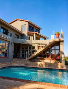 a house with a swimming pool in front of a house at Ui Views in Margate