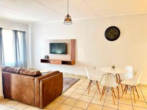 a living room with a couch and a table at Arise self catering in Burgersfort