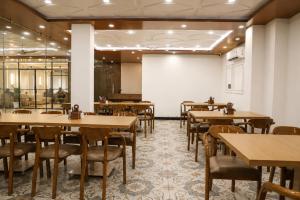 a dining room with wooden tables and chairs at The Vatika Paradise in Ayodhya