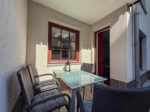 a glass table and two chairs on a patio at Haus Sachsensteinblick in Bad Sachsa