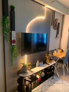 a living room with a desk with a large television at Plumera Mactan Bldg A 108 in Bankal