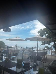 a table with chairs and umbrellas on a balcony at Plumera Mactan Bldg A 108 in Bankal +6 photos