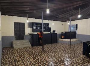 a room with a bar with a person standing in it at Kings Hotel and Lounge in Bwari