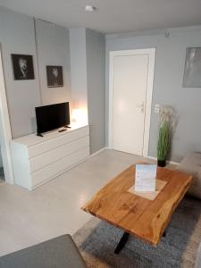 a living room with a wooden table and a tv at Stadtnest Katharine in Flensburg