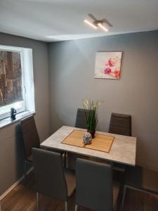 a dining room with a table and chairs and a window at Stadtnest Katharine in Flensburg +10 photos