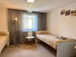 a small room with two beds and a window at Kamus in Baden-Baden