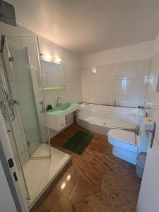 a bathroom with a tub and a toilet and a shower at Ferienunterkunft International A in Bad Harzburg