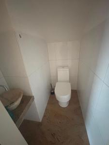 a small bathroom with a toilet and a sink at Ferienunterkunft International A in Bad Harzburg