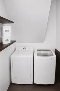 two washing machines sitting next to each other in a kitchen at Flip Flop House in Puerto Villamil