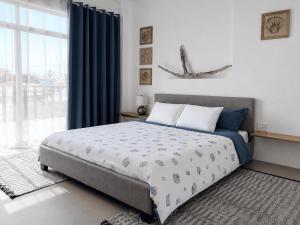 a bedroom with a bed and a large window at Flip Flop House in Puerto Villamil