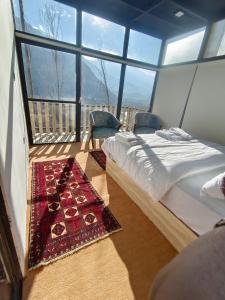 a bedroom with a bed in a room with windows at Cloud Nine And A Half in Hunza Valley