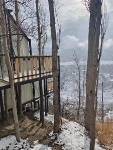 a house on a hill with snow and trees at Cloud Nine And A Half in Hunza Valley