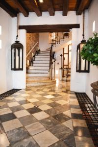 an indoor hallway with a checkered floor and stairs at Hotel Boutique Casa del Coliseo in Cartagena de Indias