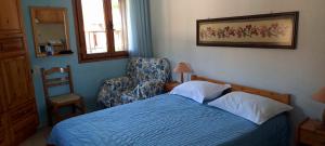 a bedroom with a bed and a chair and a window at Korinas House in Agnontas