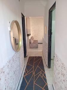 a hallway with a mirror and a couch in a room at Aïn turk oran in Aïn El Turk