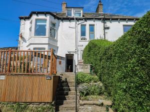 a white house with a wooden gate and stairs at Ferncliffe in Morecambe