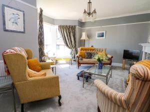 a living room with couches and a tv at Ferncliffe in Morecambe