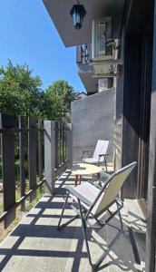 two chairs sitting on a patio with a fence at Stan apartman Kolašin in Kolašin