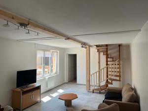a living room with a couch and a television at Chez JC in Drouvin-les-Marais