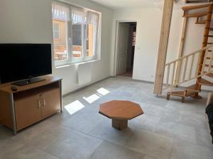 a living room with a flat screen tv and a table at Chez JC in Drouvin-les-Marais +1 photo