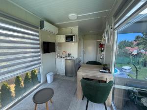 an rv kitchen and dining area with a table and a window at Ailleurs in Novi Banovci