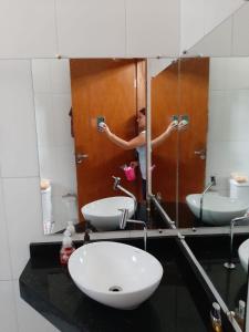 a person taking a picture in a bathroom mirror at Sitio ALI in Cachoeira Paulista +9 photos