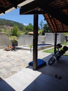 a motorcycle parked under a pavilion next to a pool at Sitio ALI in Cachoeira Paulista
