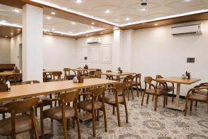 a dining room with wooden tables and chairs at The Vatika Paradise in Ayodhya