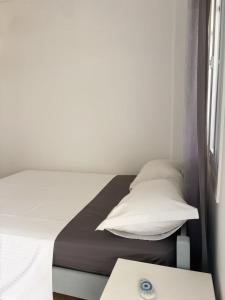 a small bedroom with a bed and a window at Lefkanemos in Tourlos