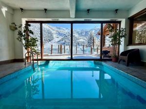 a swimming pool with a view of a snowy mountain at Hotel Punta Condor in San Carlos de Bariloche