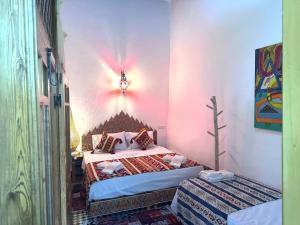 a bedroom with a bed in a pink room at Riad Rita in Meknès