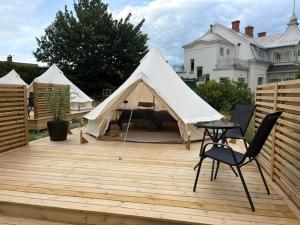 a white tent on a wooden deck with a table and chairs at Hotell Briggen i Åhus in Åhus