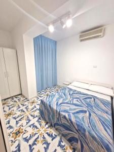 a bedroom with a bed with a blue and white comforter at Sea View MdG in Marina di Gioiosa Ionica