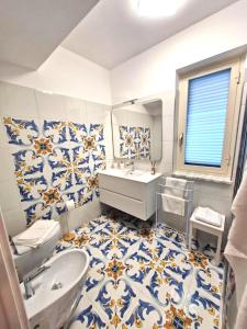 a bathroom with blue and white tiles on the floor at Sea View MdG in Marina di Gioiosa Ionica +14 photos